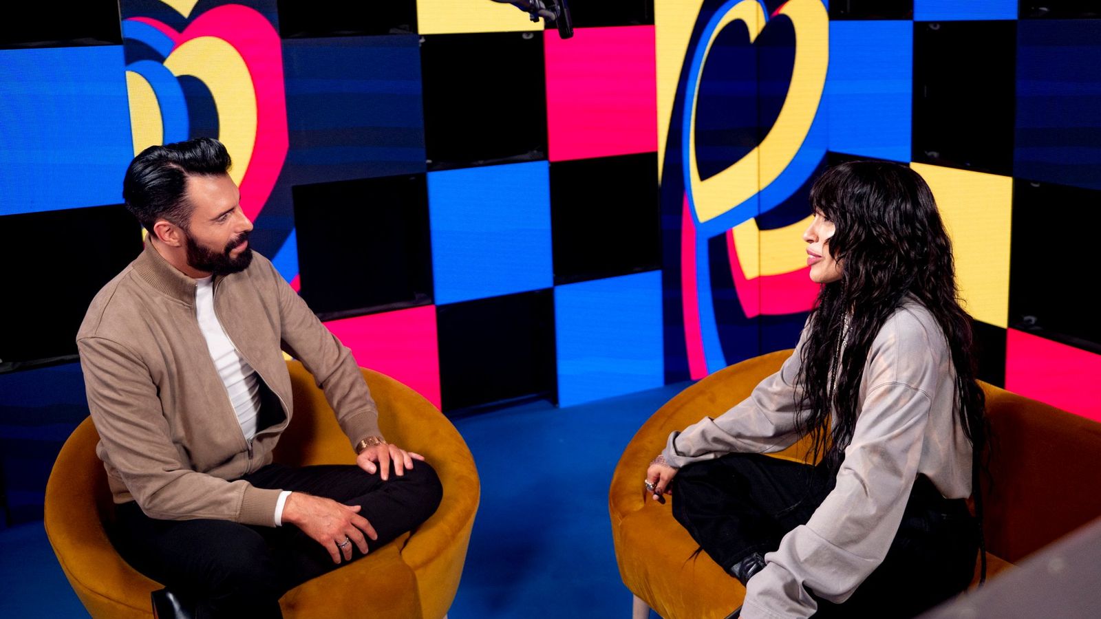 Rylan and Loreen deep in conversation during an episode of Be My Guest