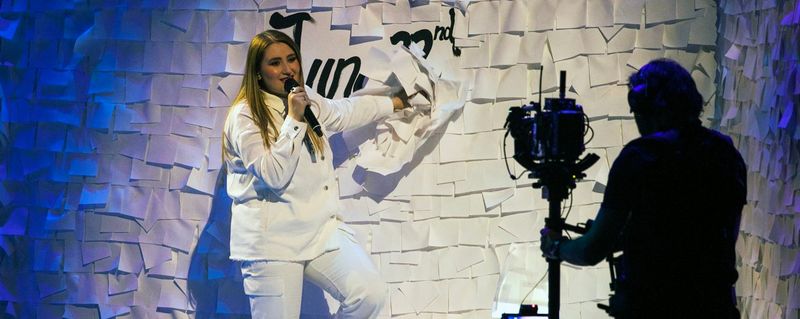 Rosa Linn performing Snap in front of a Rai camera operator